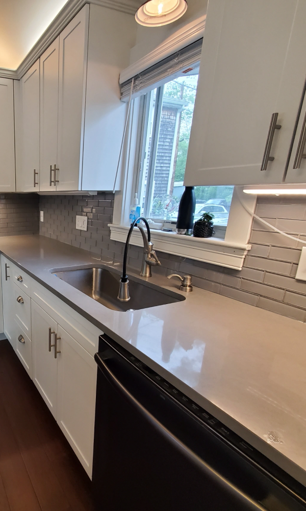 white kitchen with marble countertop.