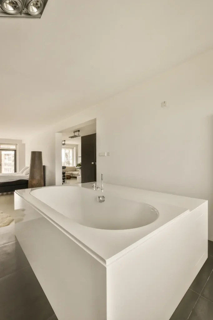 Bright all-white bathroom with large walk-in bathtub and natural lighting.