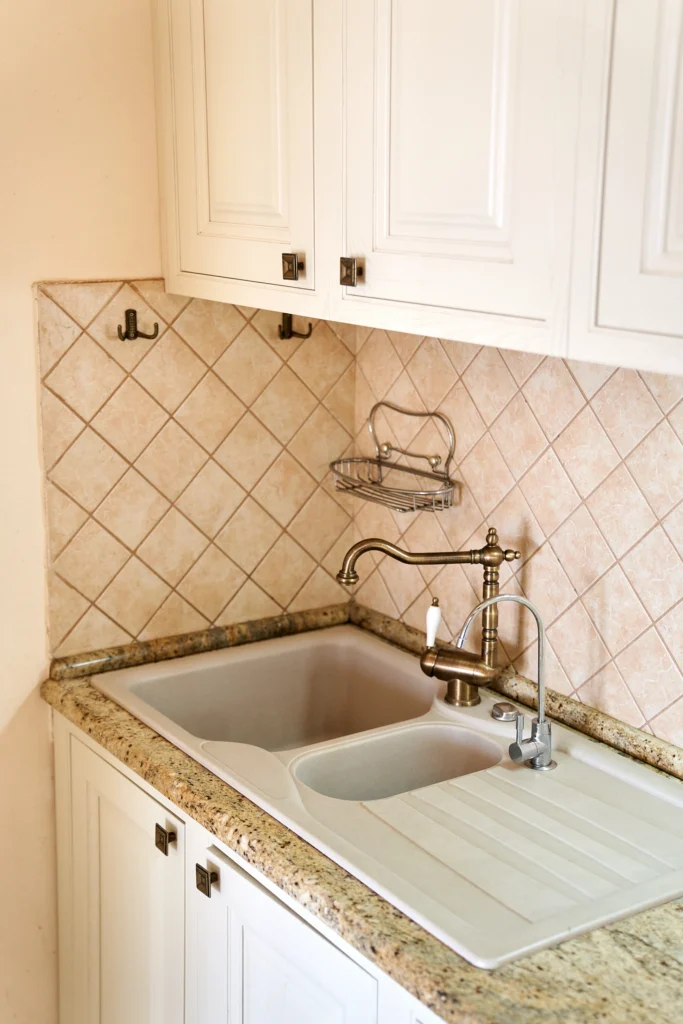 Backsplash tiles being set in sink during kitchen renovation.