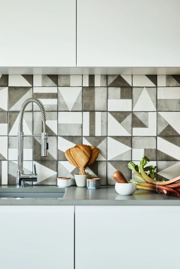 Kitchen backsplash tiles being installed above countertop.
