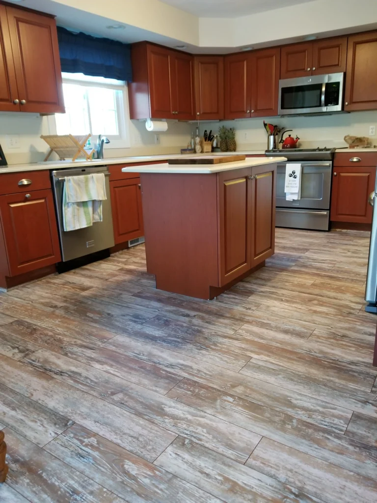 Wooden base cabinets being aligned and fixed during kitchen installation.