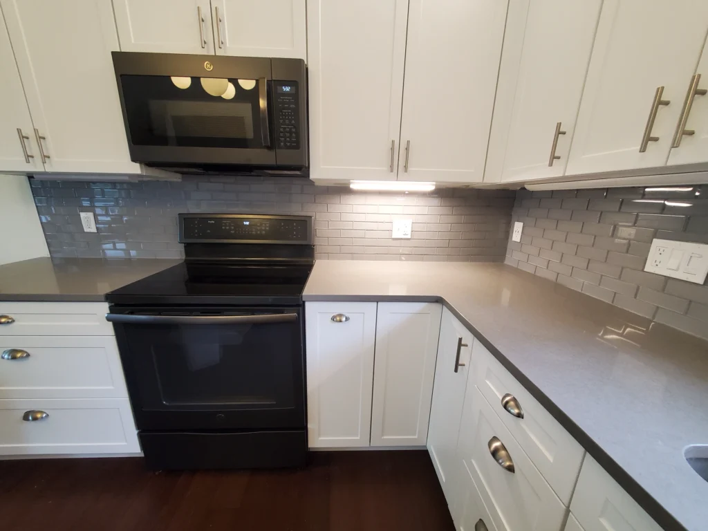 White kitchen cabinet installation with marble countertop.