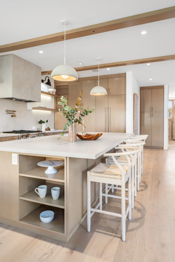Modern kitchen after renovation featuring island, pendant lights.