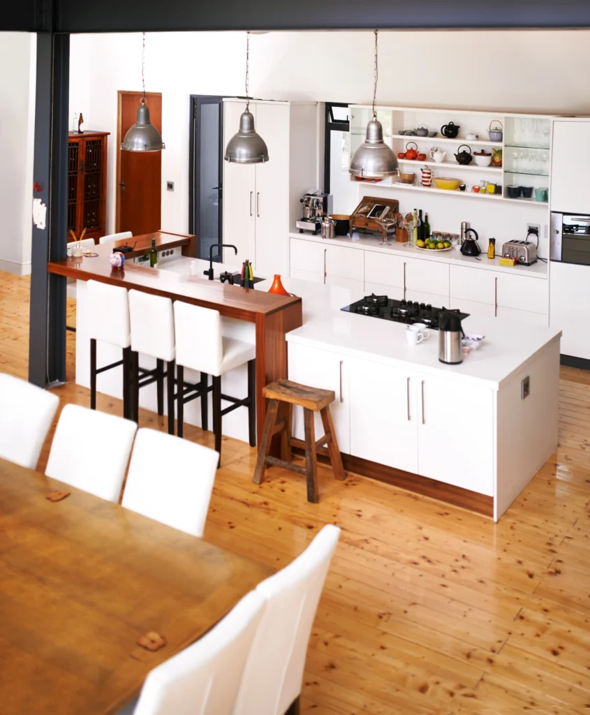 Remodeled open-concept kitchen with hardwood floors and stainless steel appliances.