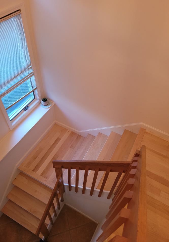 Wooden staircase being sanded during refinishing project.