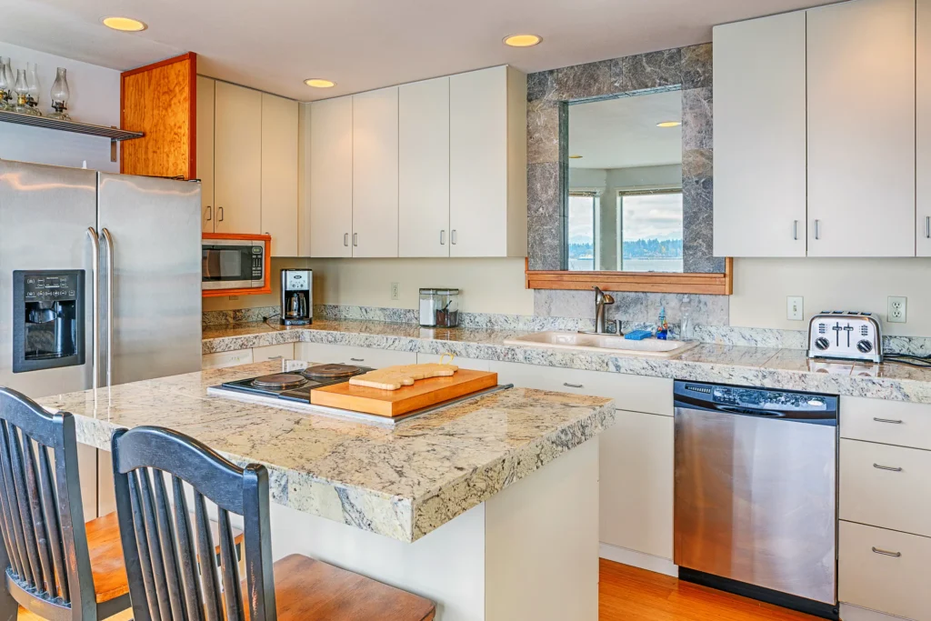 A modern kitchen featuring a granite countertop and light-colored cabinetry, illustrating a stylish and functional countertop choice for small spaces.