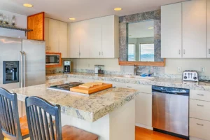 A modern kitchen featuring a granite countertop and light-colored cabinetry, illustrating a stylish and functional countertop choice for small spaces.