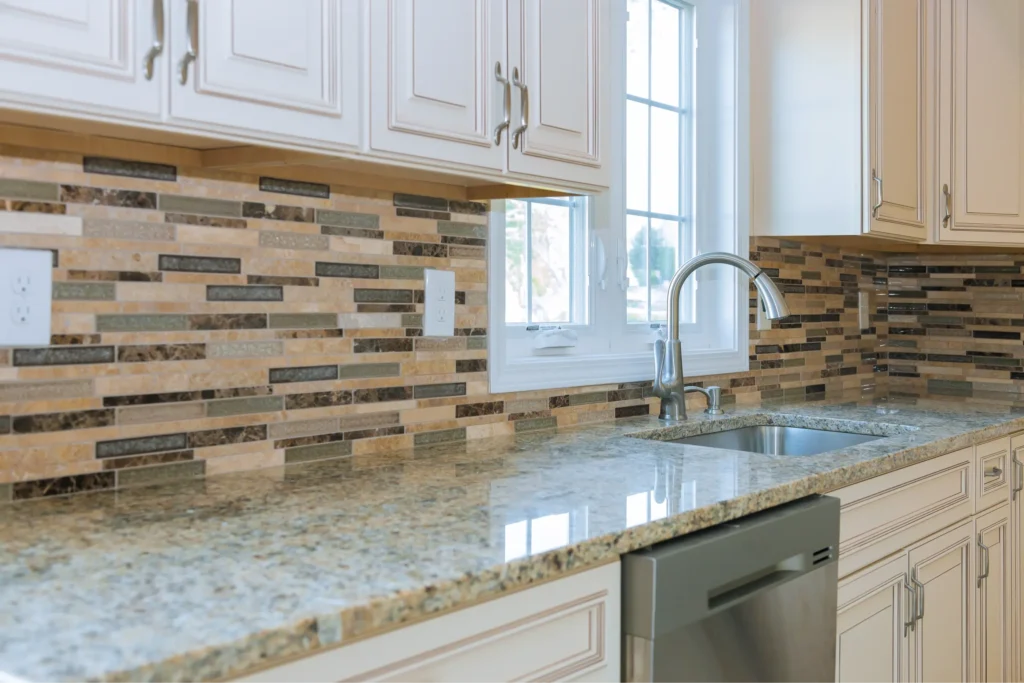 Granite countertops and a mosaic tile backsplash in a kitchen. This image showcases the materials often used in kitchen renovations and backsplash projects.