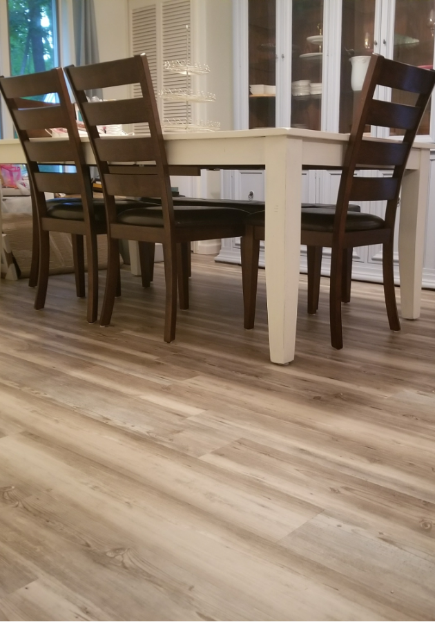 Refinished hardwood floors with glossy finish in modern dining area.