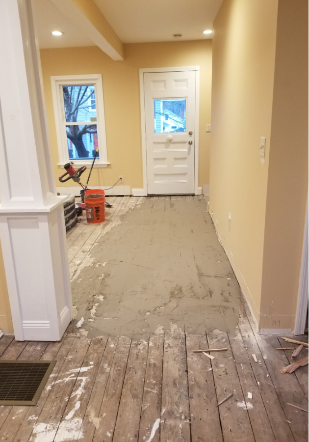 Damaged subfloor with visible cracks prior to leveling treatment.