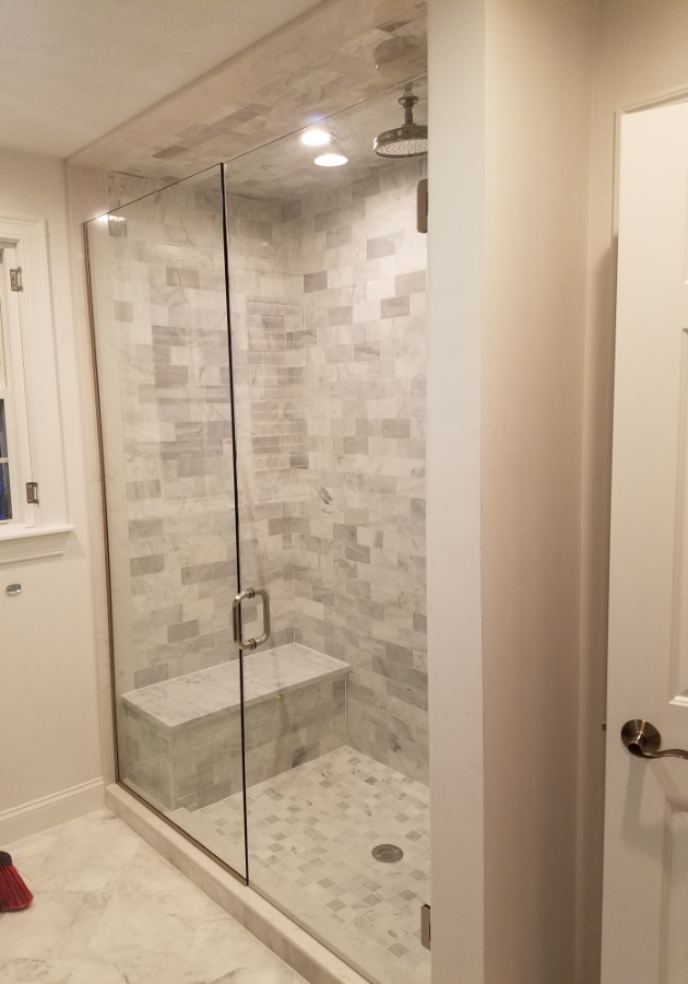 white subway tiles walls in a modern walk-in shower.