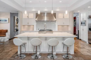 A modern kitchen featuring a large, central kitchen island with seating, ample counter space, and stylish cabinetry. The island is a focal point of the bright, spacious kitchen.