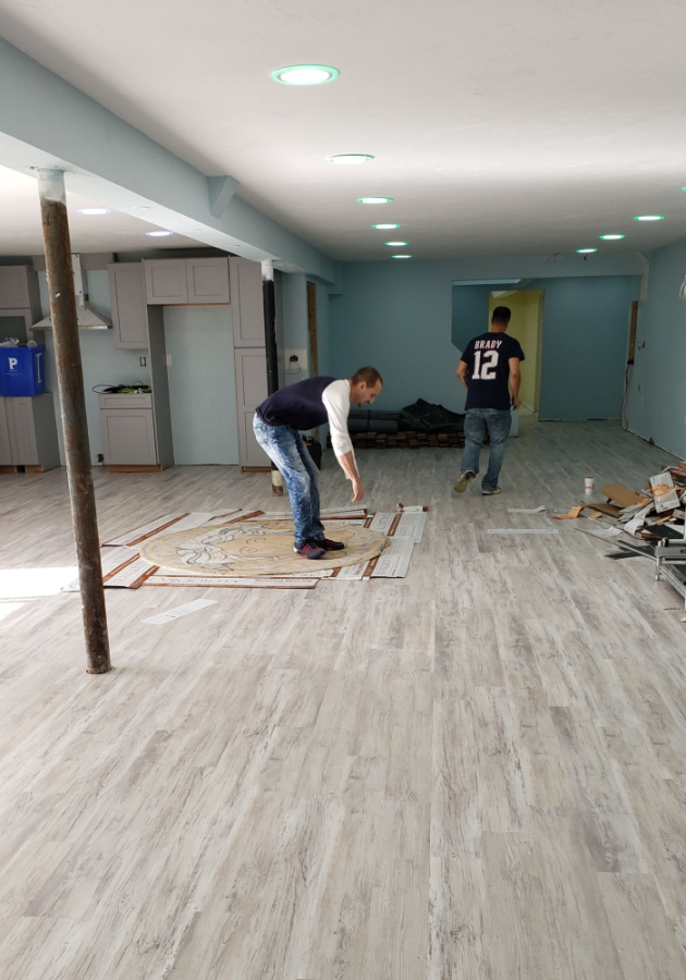 Professional team during luxury vinyl plank flooring installation.