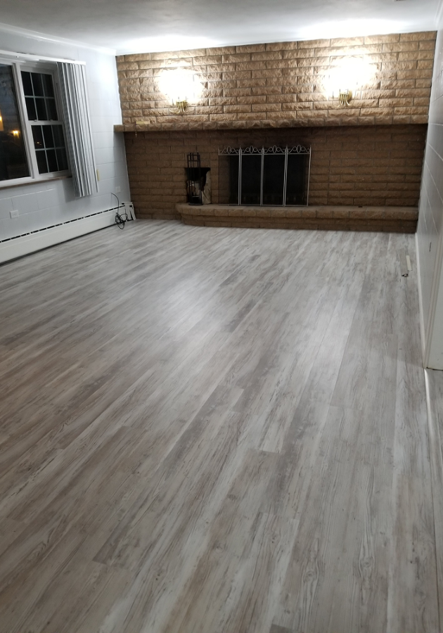 Luxury vinyl plank flooring being installed in a living room.