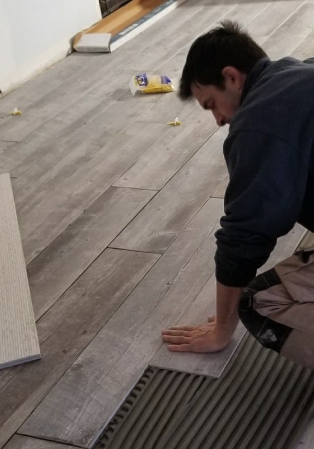 Professional team during vinyl plank flooring .